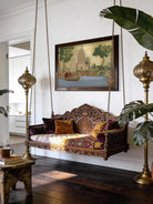 Kashi Reverie Wallart - Marble Lotus - A sophisticated living room featuring Kashi Reverie temple art styled above a carved wooden jhoola swing and ornate brass floor lamps.