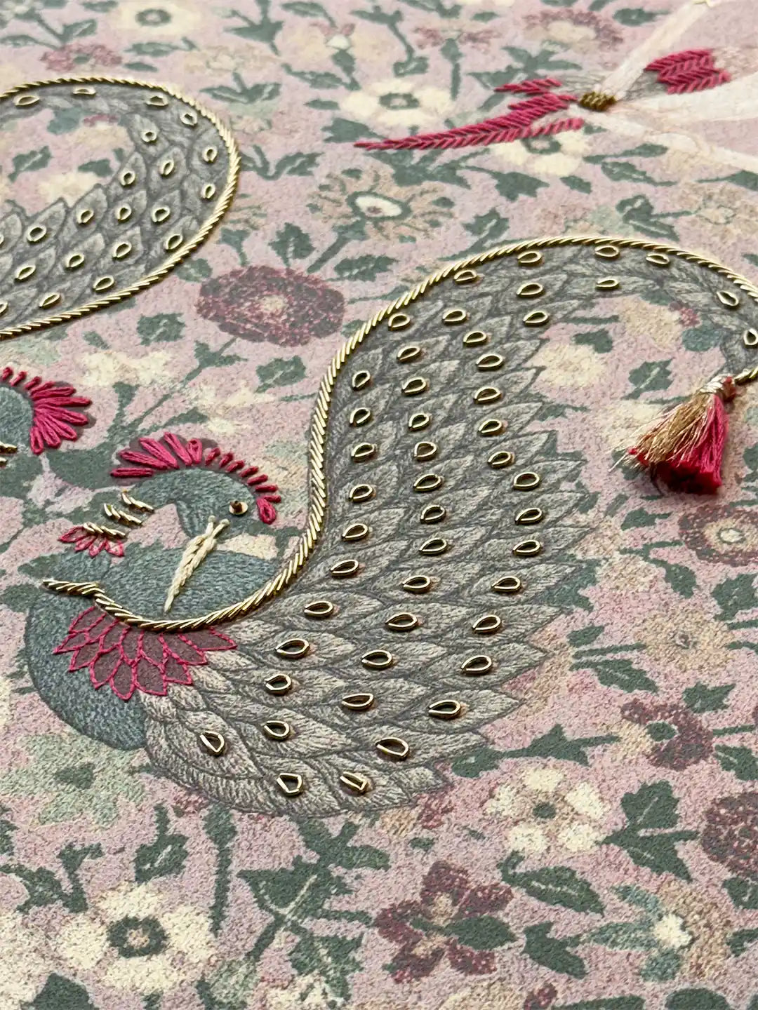 High-detail shot of a majestic peacock motif with gold metallic cording and three-dimensional bead accents